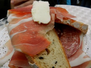 Italian meats and cheeses piled high on a wooden platter. Topped with a slab of butter...so German