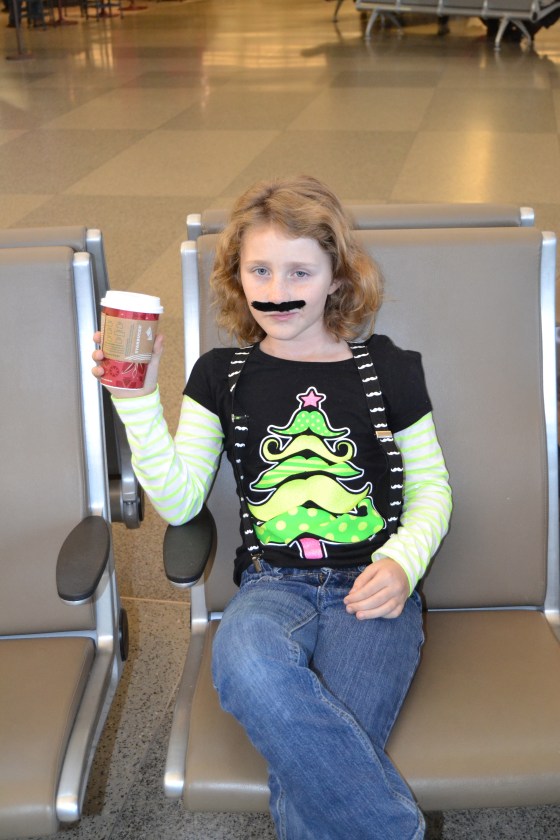 Lilly casually drinks her hot chocolate even though the stache gets in the way of the whipped cream