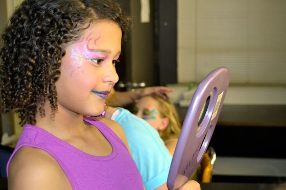 A team of moms devoted their time to doing stage makeup for the cast. Here, a mermaid admires her new look